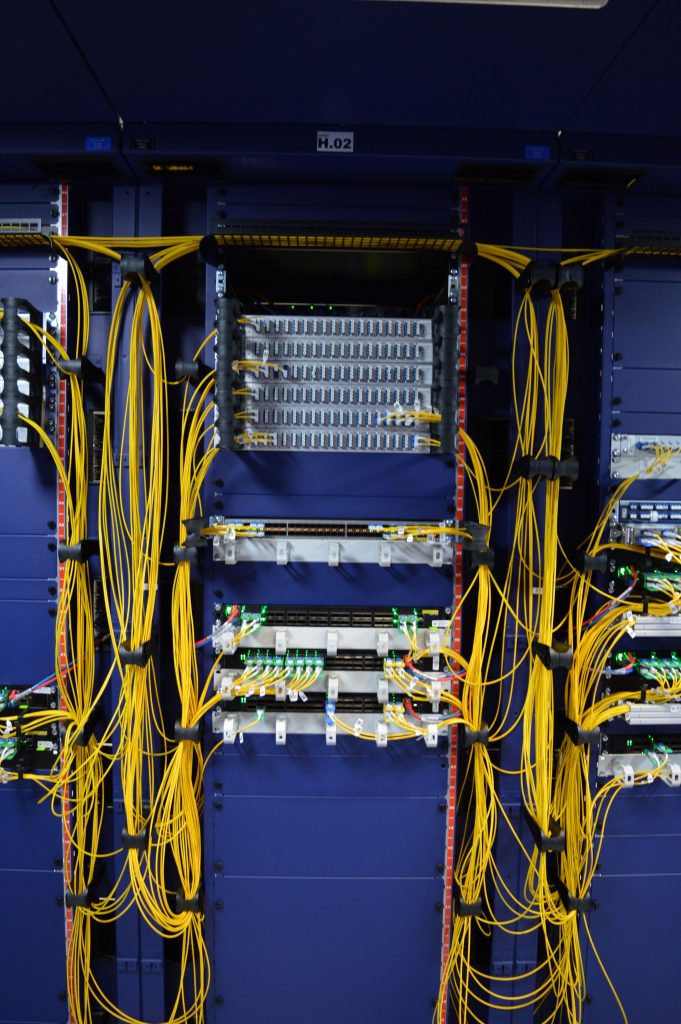 Detailansicht der sauberen und professionellen Netzwerkverkabelung an der Rückseite von Servern in einem Rack, mit ordentlich gebündelten, gelben Datenkabeln.