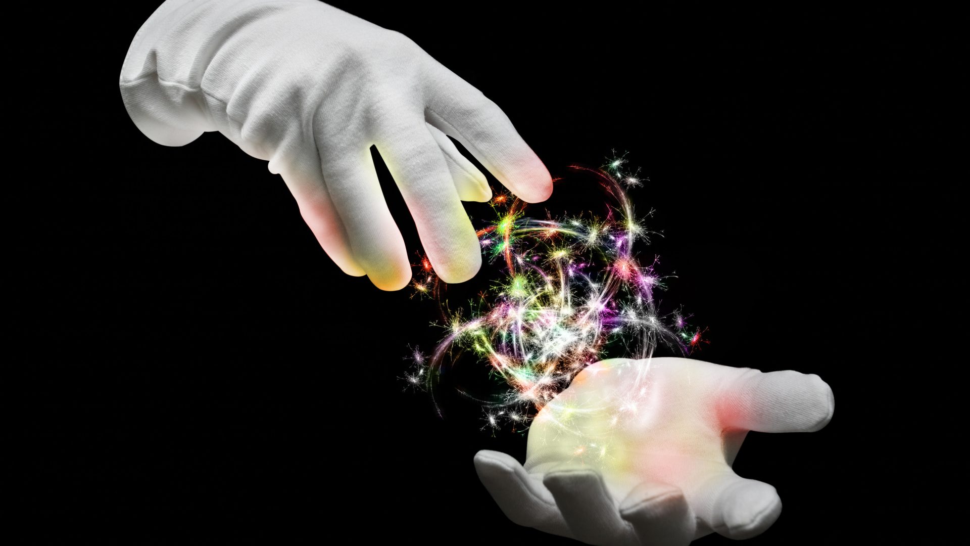 The hands of a magician with colored lights