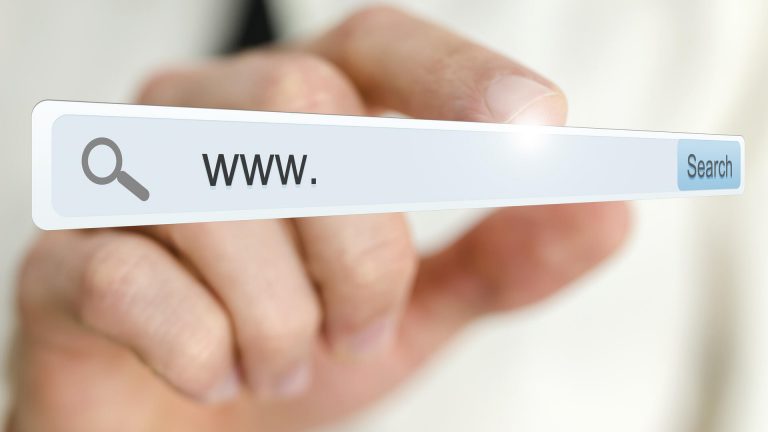Eine Hand tippt auf ein virtuelles Suchfeld im Browser, symbolisch für Domain-Registrierungen in 2026 und Web-Suche.